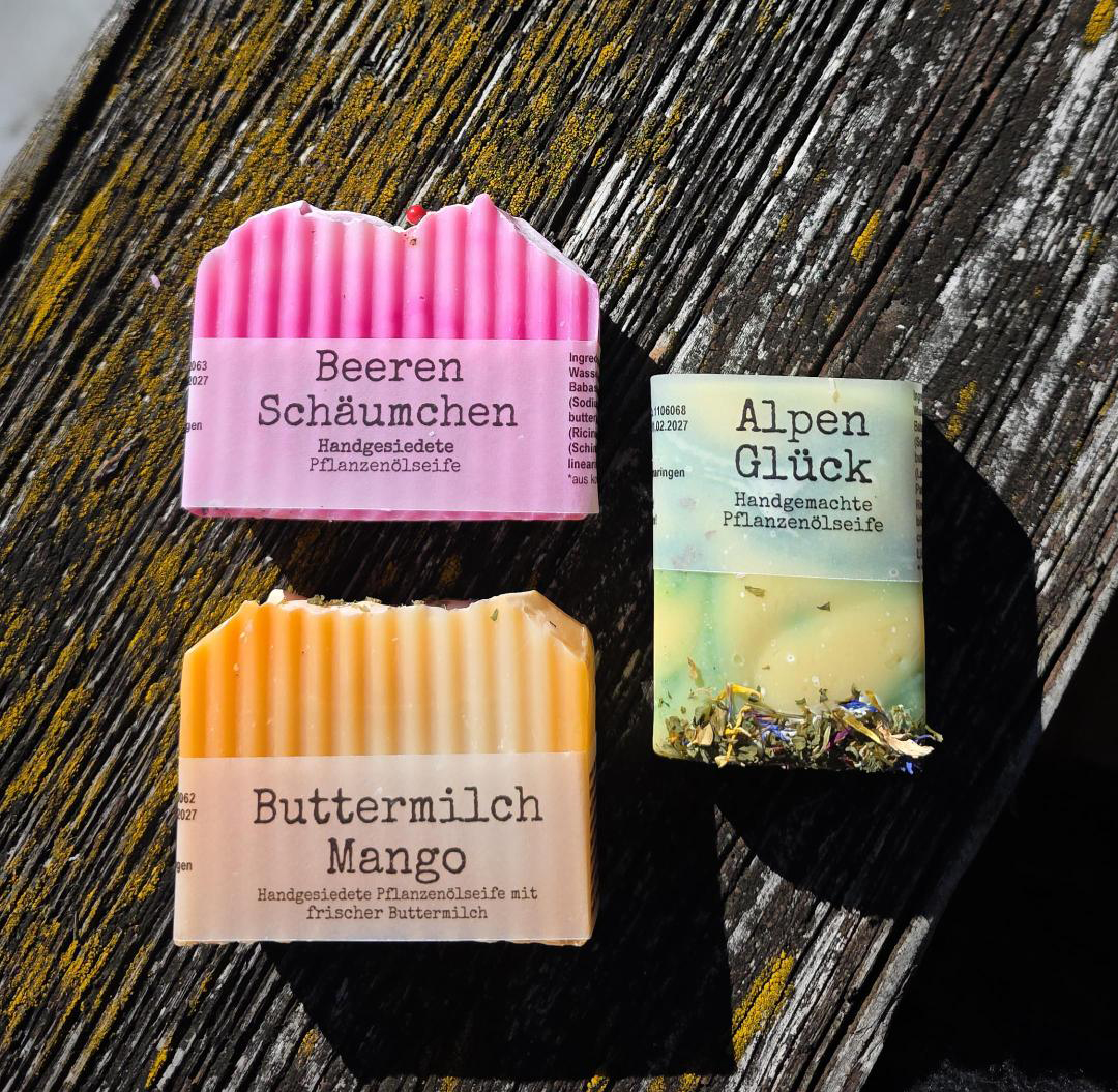 Premiumseifen 3er Bundle mit BeerenSchäumchen, ButtermilchMango und AlpenGlück auf verwittertem Holz.