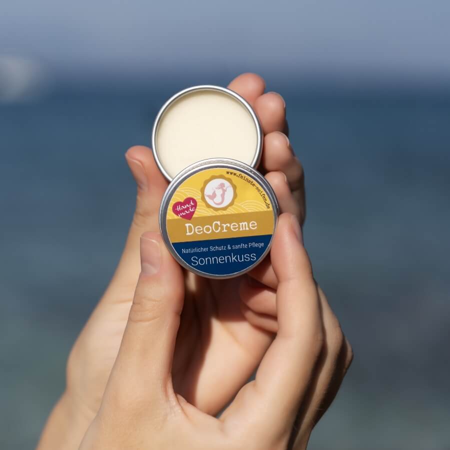 Geöffnete Mini DeoCreme Sonnenkuss in der Hand – Naturdeo im 15-g-Reiseformat