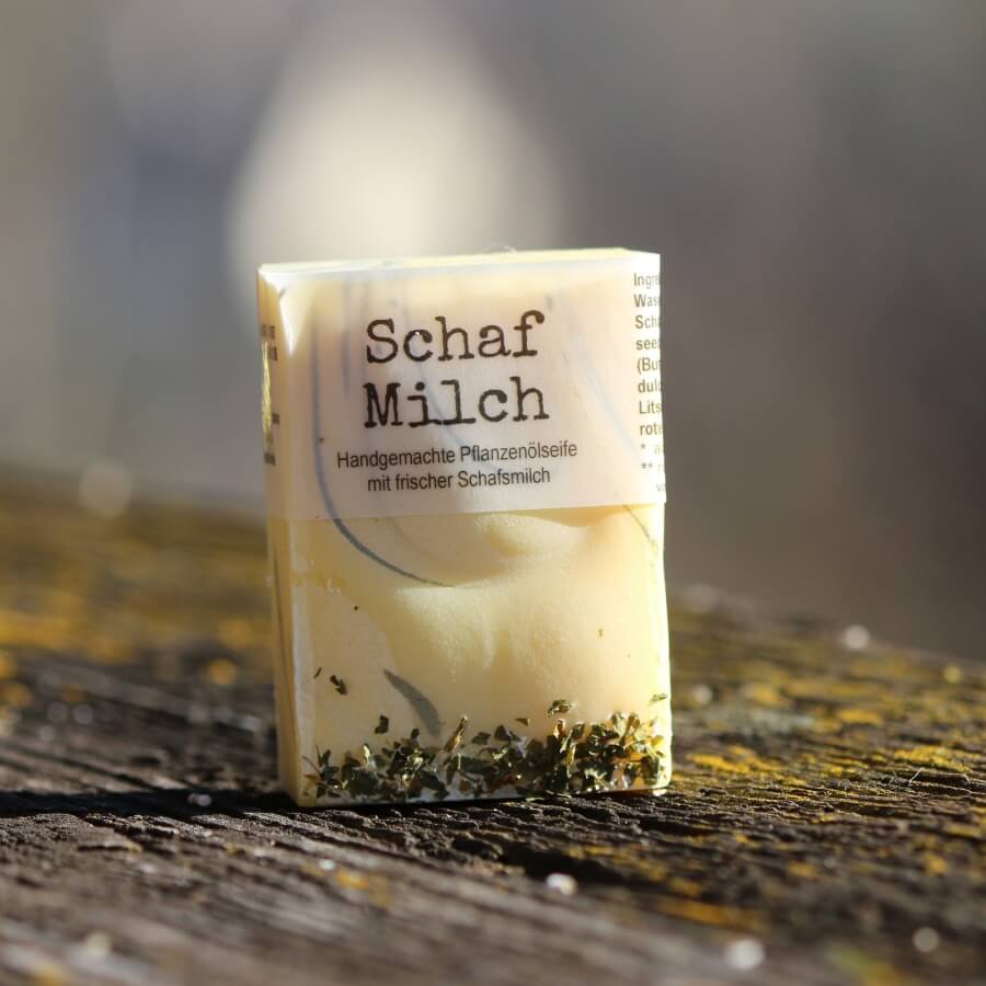 Handgemachte SchafMilch Pflegeseife mit frischer Schafmilch auf verwittertem Holz – cremige Naturseife für Hände, Gesicht und Dusche.